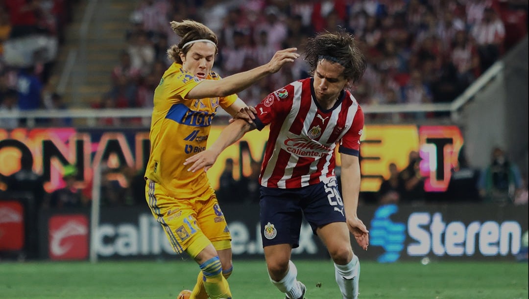 JUGADORES DE CHIVAS Y TIGRES PELEAN UNA PELOTA DURANTE UN PARTIDO DE LIGA MX