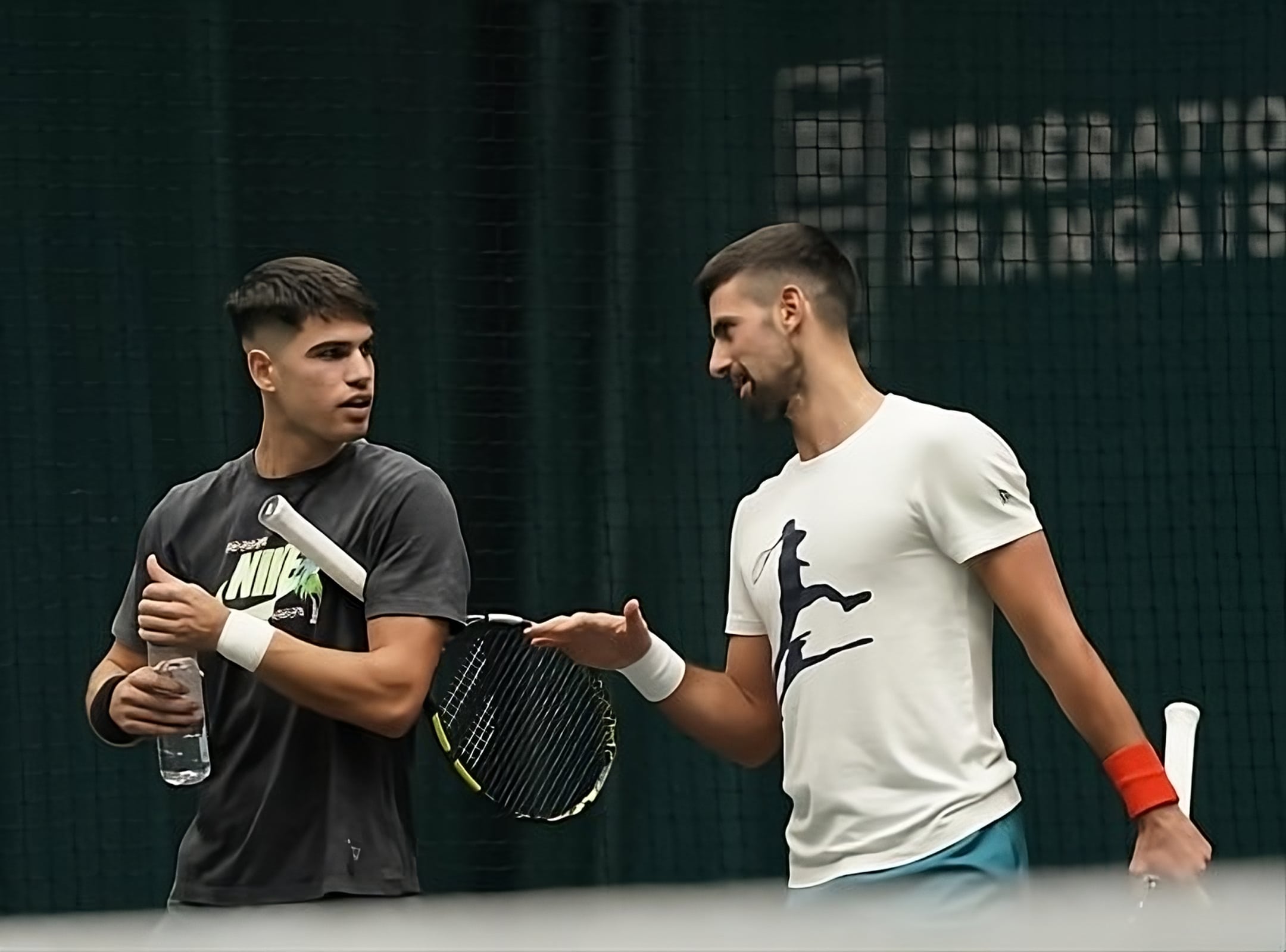 CARLOS ALCARAZ A LA IZQUIERDA Y NOVAK DJOKOVIC A LA DERECHA DURANTE UN ENTRENAMIENTO DE TENIS