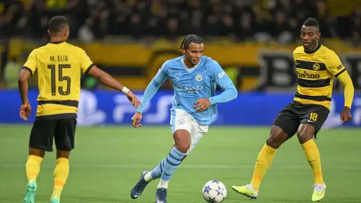 Akanji yéndose entre dos defensas