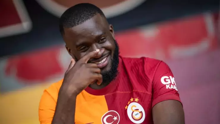 Ndombelé riéndose con la mano en la cara