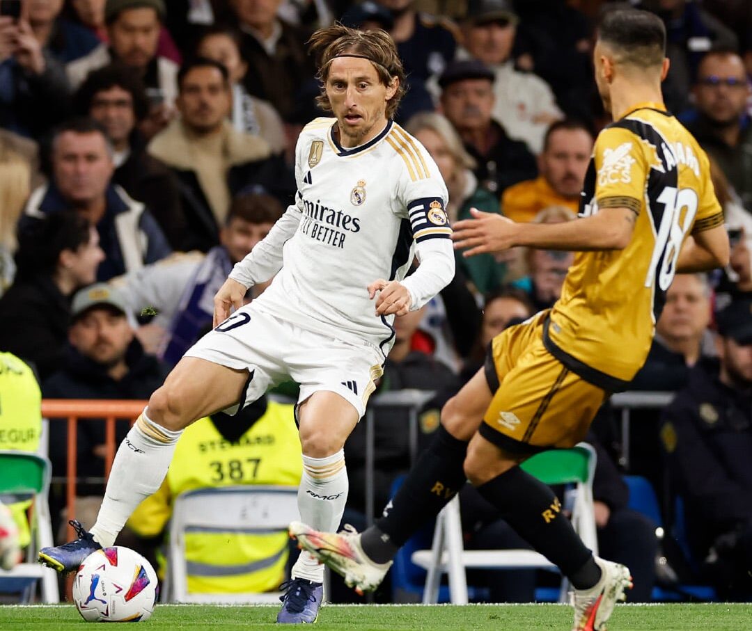 Modric conduciendo el balón ante un rival
