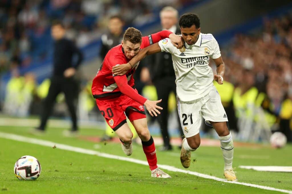 Rodrygo y un defensa del Rayo forcejeando por el balón