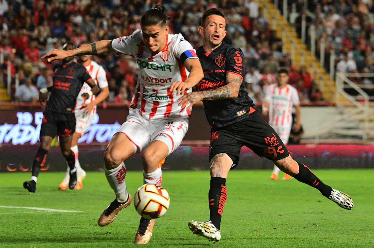 'Huevo' Lozano compitiendo con Alexis Peña por el balón
