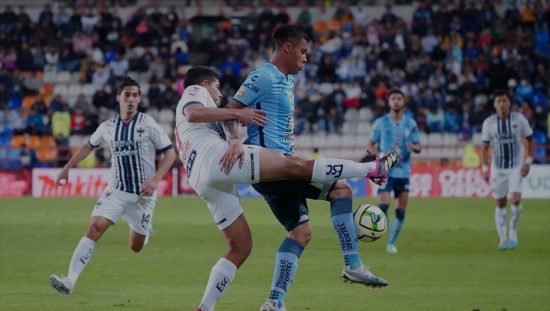 JUGADORES DE RAYADOS Y PACHUCA SE DISPUTAN UN BALÓN EN UN PARTIDO PREVIO