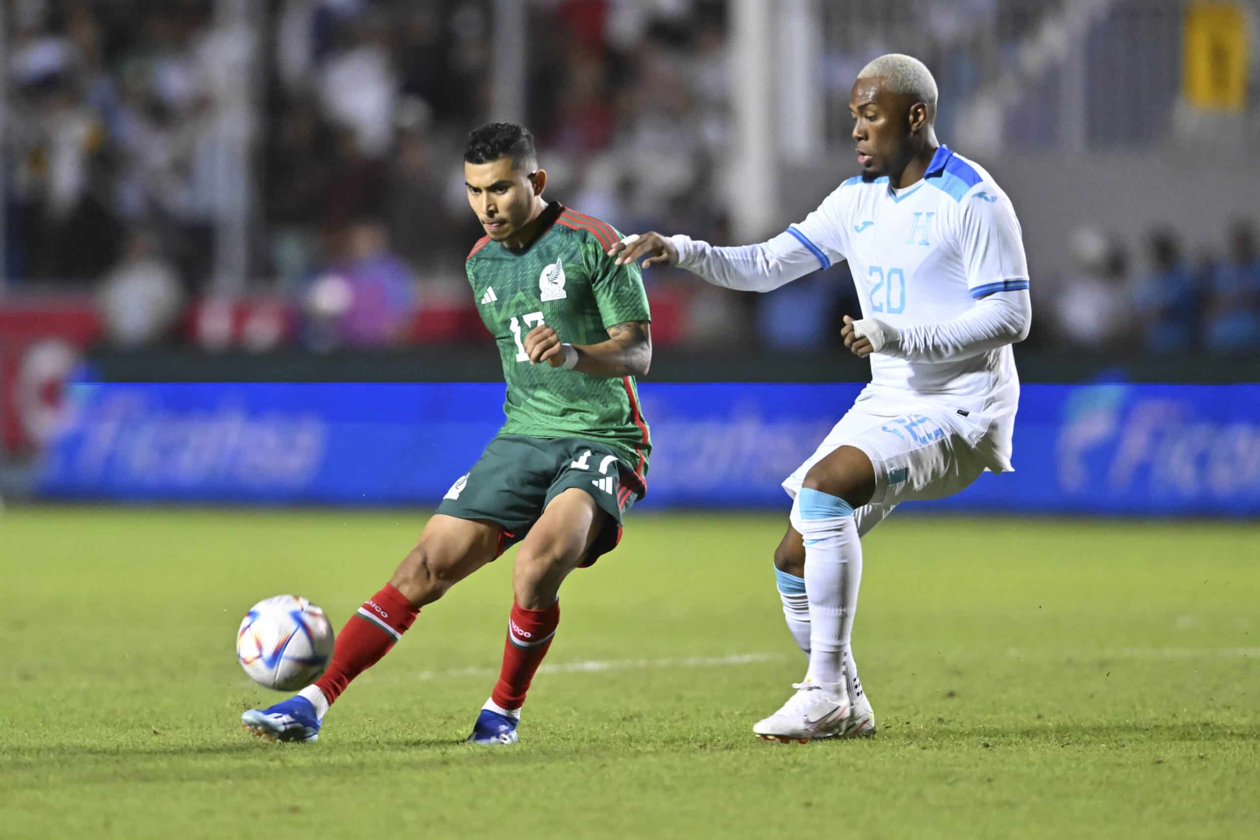 ORBELÍN PINEDA DOMINA EL BALÓN CON UN DEFENSOR HONDUREÑO DEFENDIÉNDOLO