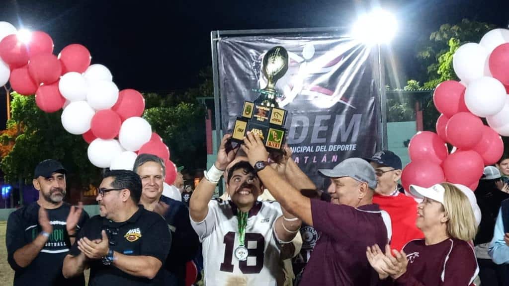 JUGADOR DE BURROS SALVAJES LEVANTA EL TROFEO DE CAMPEONATO