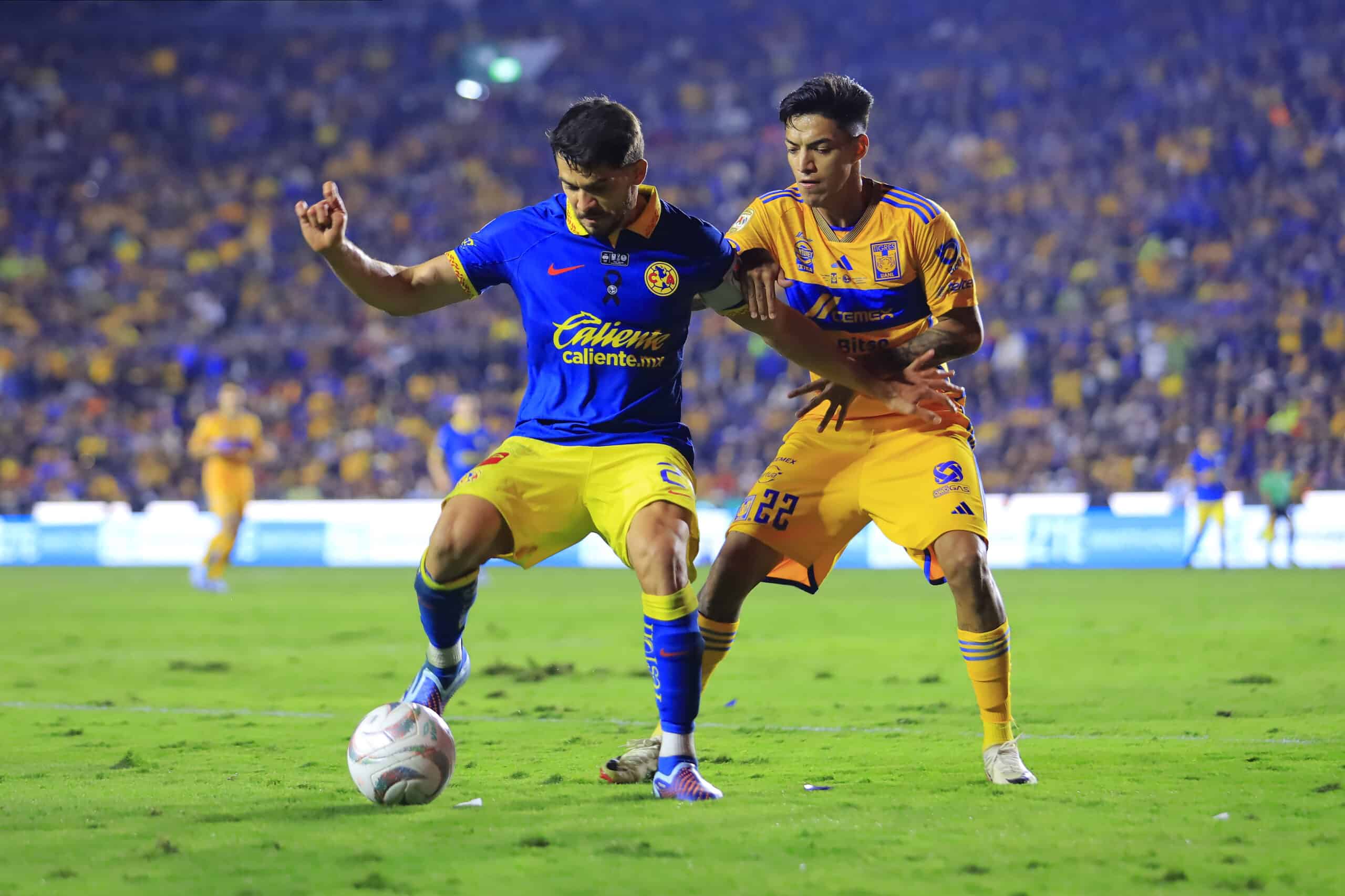 Henry Martin (I) del America y Raymundo Fulgencio (D) del Tigres disputan el balón durante el juego de ida de la Final.