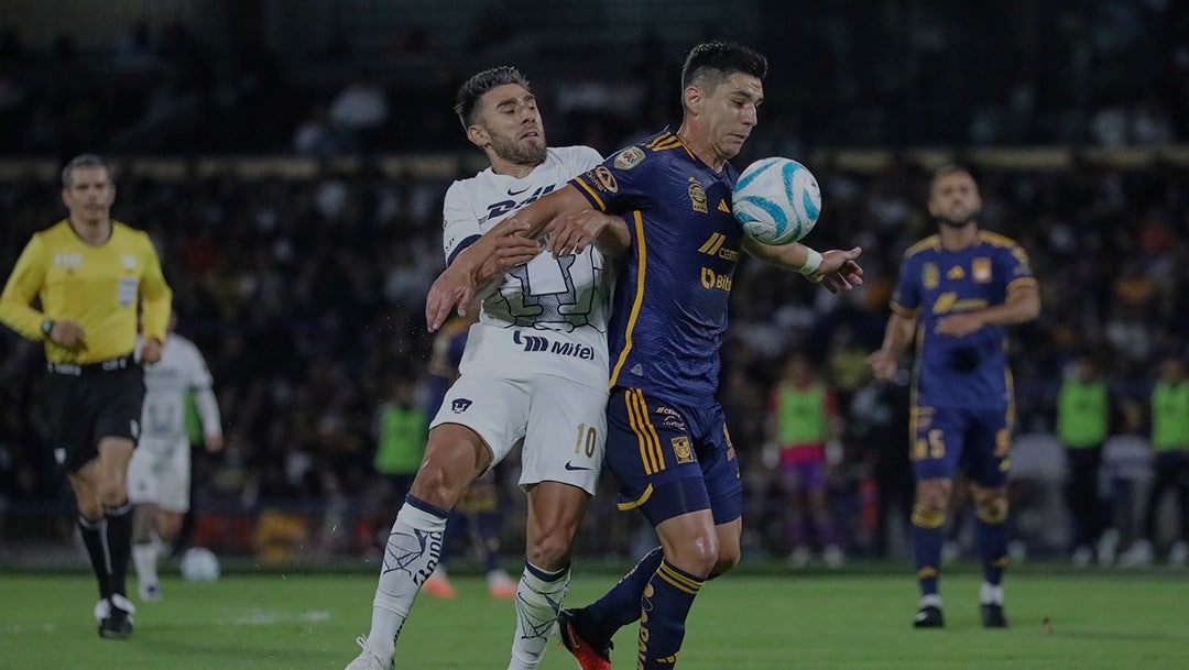 JUGADORES DE PUMAS Y TIGRES SE DISPUTAN LA POSESIÓN DEL BALÓN