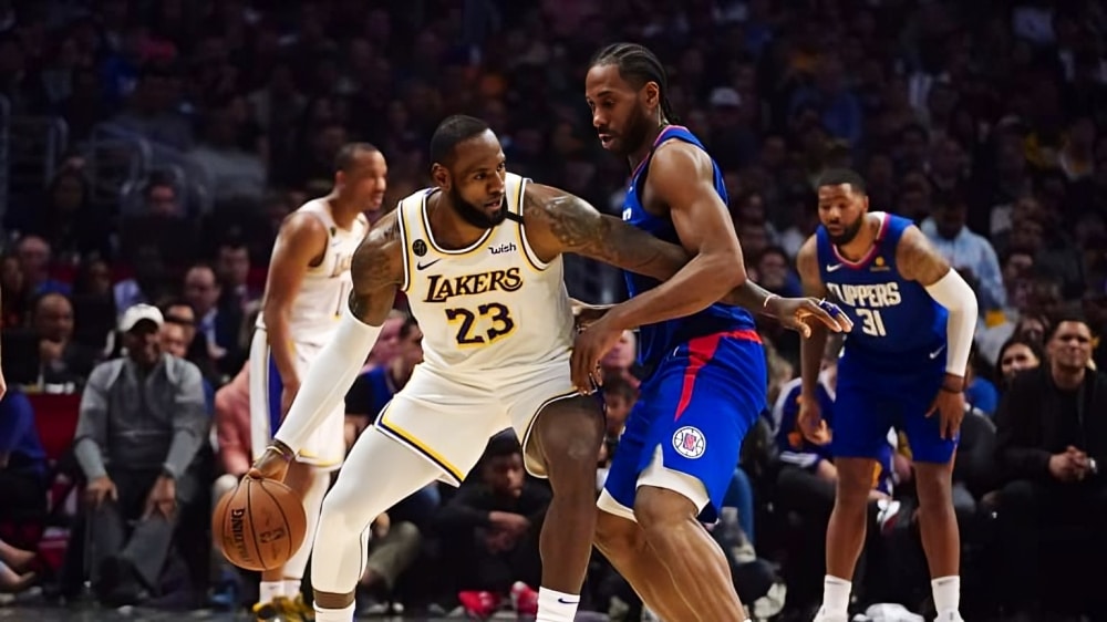 LEBRON JAMES A LA IZQUIERDA DE LAKERS DEFENDIDO POR KAWHI LEONARD DE CLIPPERS A LA DERECHA