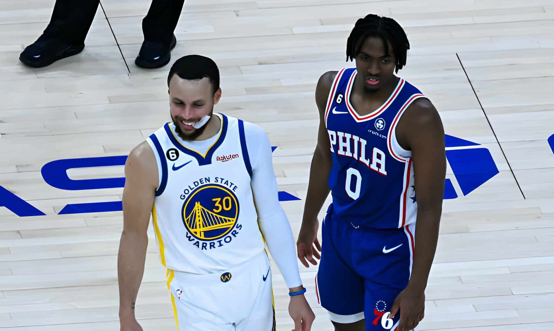 STEPHEN CURRY A LA IZQUIERDA DE LOS WARRIORS Y TYRESE MAXEY A LA DERECHA DE LOS SIXERS