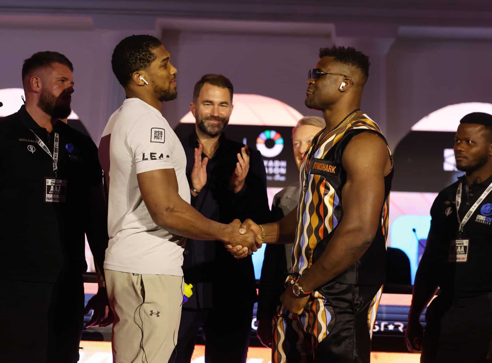 ANTHONY JOSHUA A LA IZQUIERDA Y FRANCIS NGANNOU A LA DERECHA, SE DAN LA MANO TRAS LA CONFERENCIA DE PRENSA