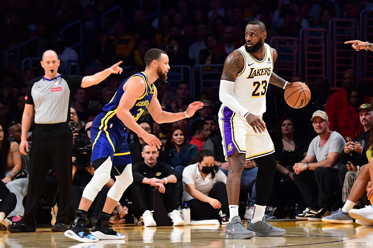 STEPHEN CURRY A LA IZQUIERDA DE LOS WARRIORS DEFENDIENDO A LEBRON JAMES DE LOS LAKERS