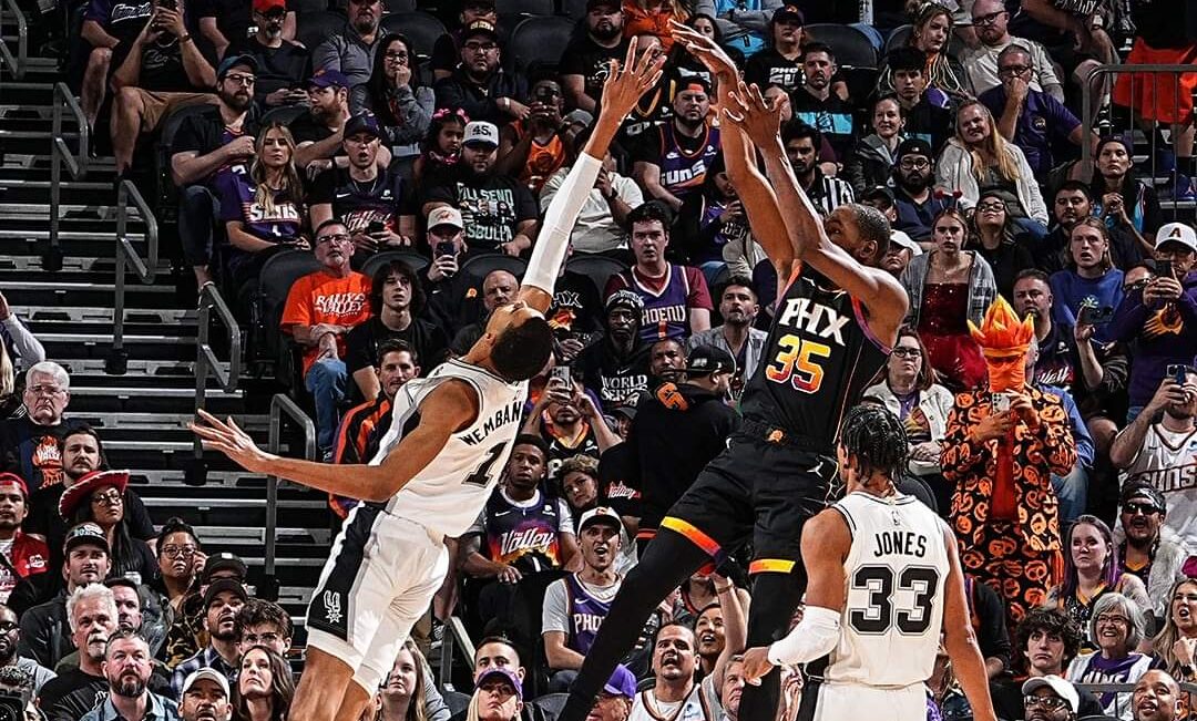 VÍCTOR WEMBANYAMA DE LOS SPURS DEFENDIENDO A KEVIN DURANT DE LOS SUNS