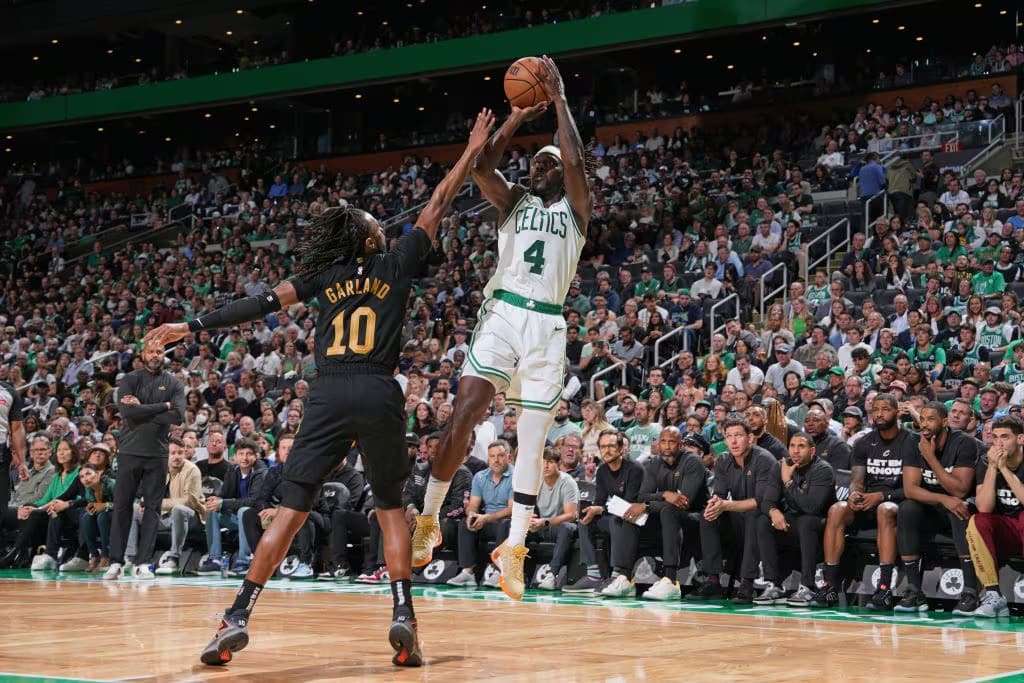 JRUE HOLIDAY DE LOS CELTICS REALIZA UN TIRO SOBRE DARIUS GARLAND DE LOS CAVALIERS